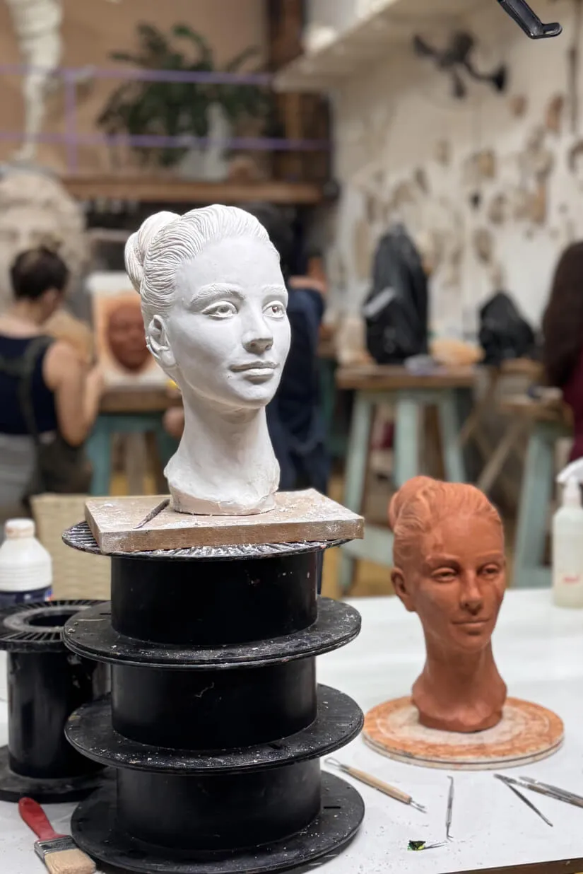 Busto branco em cerâmica sobre pedestal no ateliê